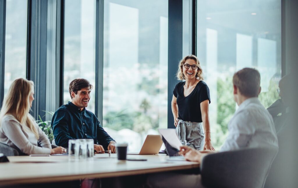 professionals sitting at and standing near a desk in their office