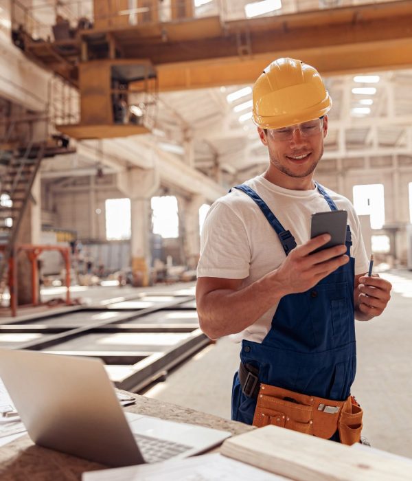 construction worker smiling while looking at phone